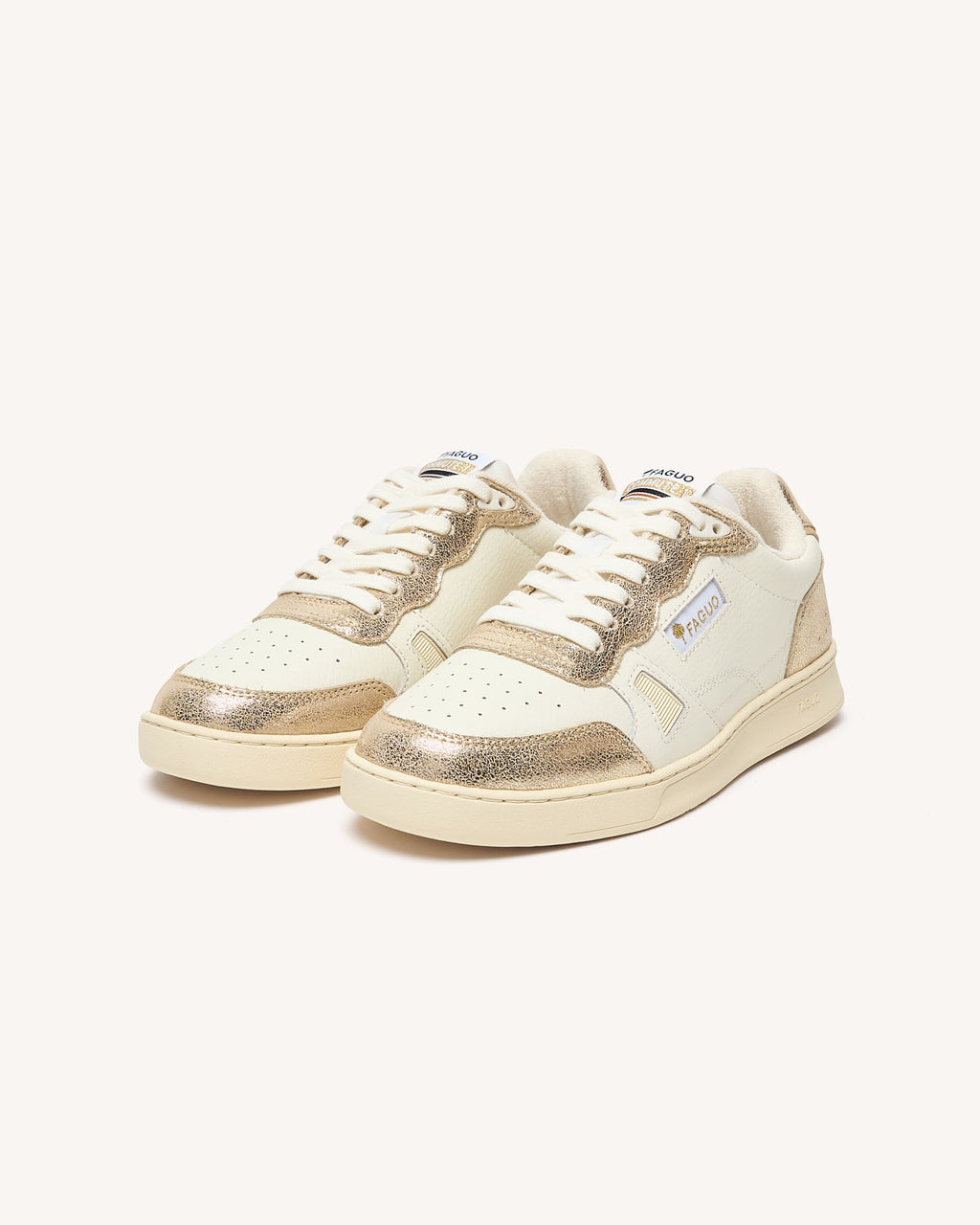 Sneakers van crèmekleurig leer met goudkleurige accenten