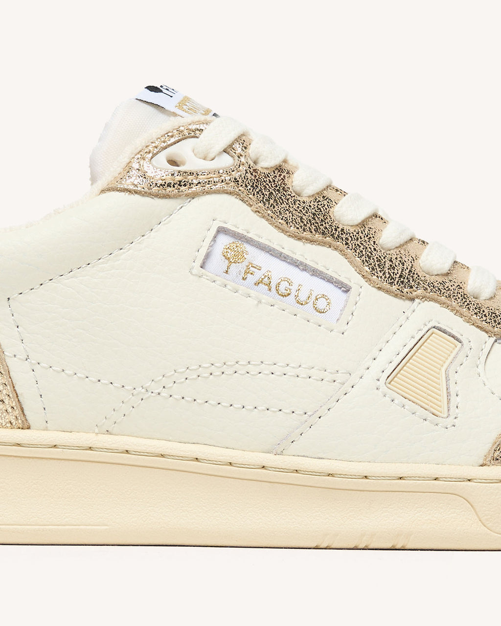 Sneakers van crèmekleurig leer met goudkleurige accenten