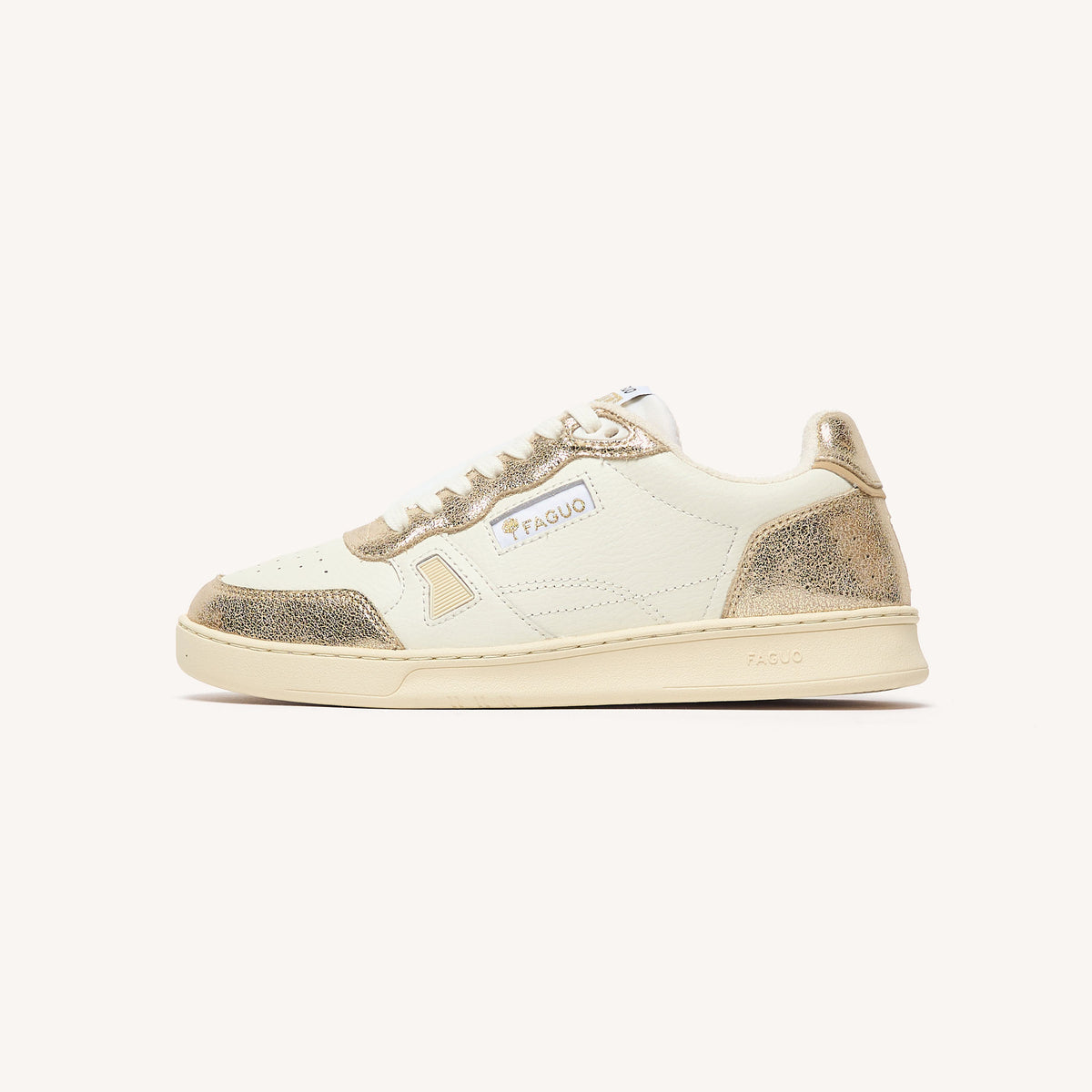 Sneakers van crèmekleurig leer met goudkleurige accenten